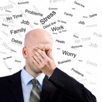 Image of man looking as if he feels overwhelmed with words such as "stress" and "work" flying around his head.